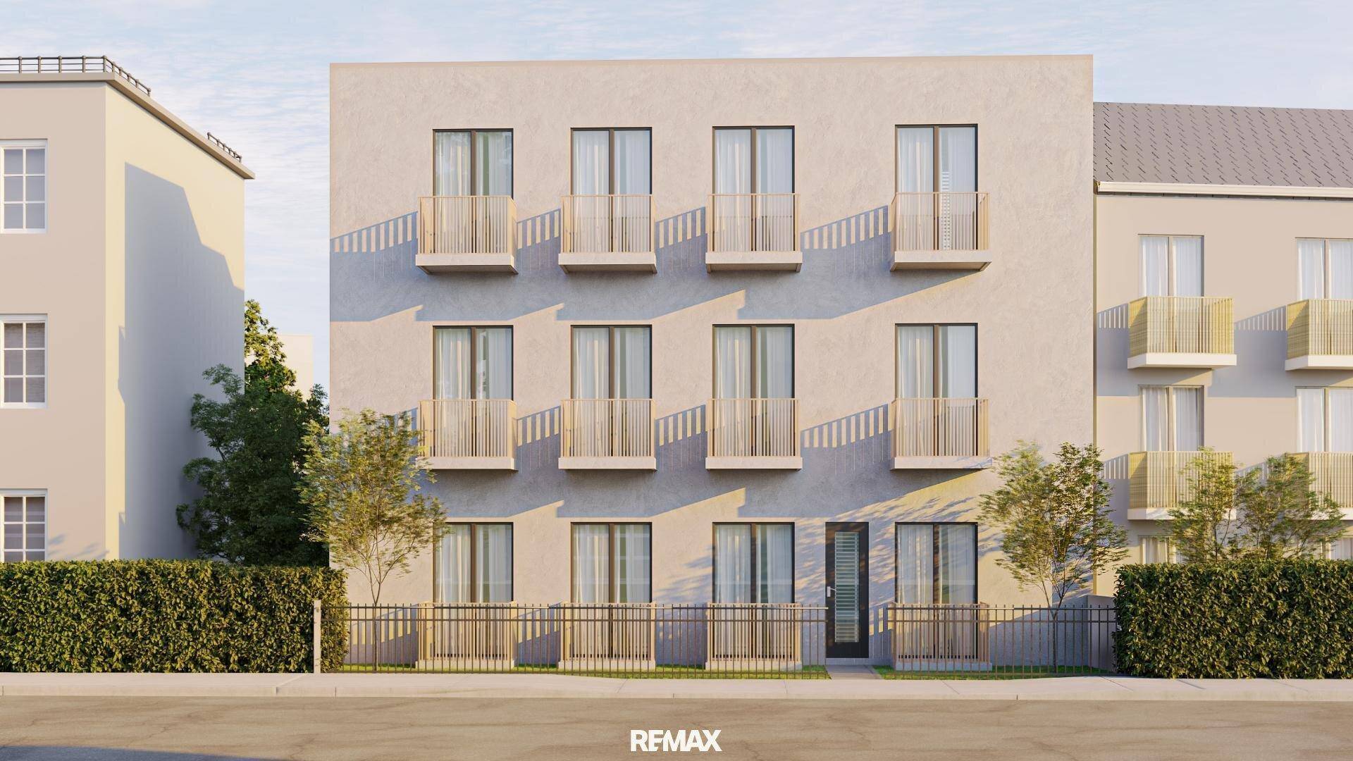 Zeitgenössische Wohnhausfassade mit vielen französischen Balkonen und einer gepflegten Hecke.