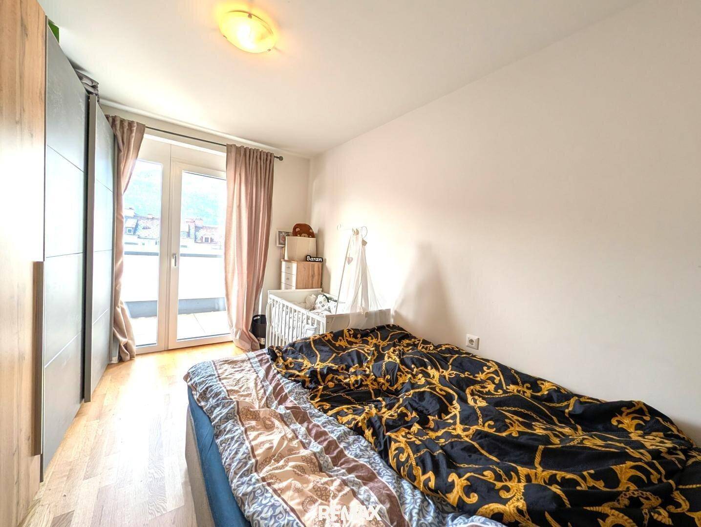 Gemütliches Schlafzimmer mit Doppelbett, Kleiderschrank und direktem Zugang zum Balkon.