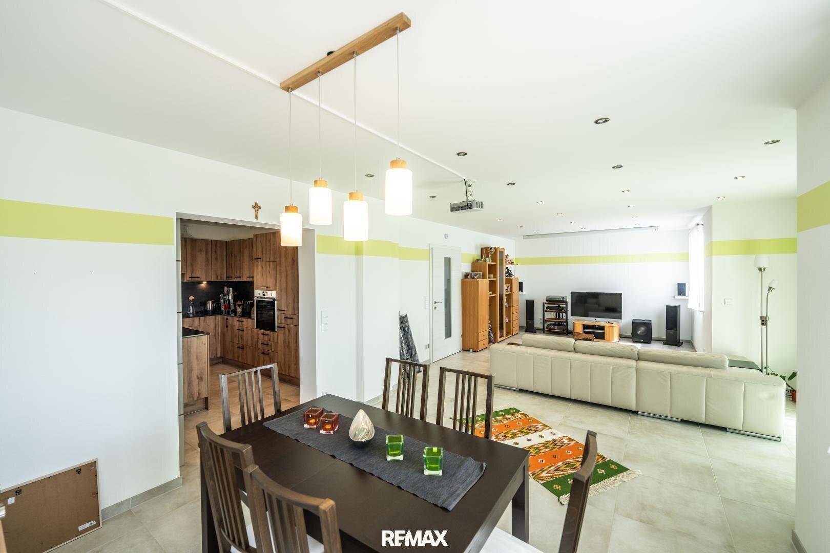 Essbereich mit Holztisch und Blick in die moderne Holzküche, ideal für gesellige Abende.
