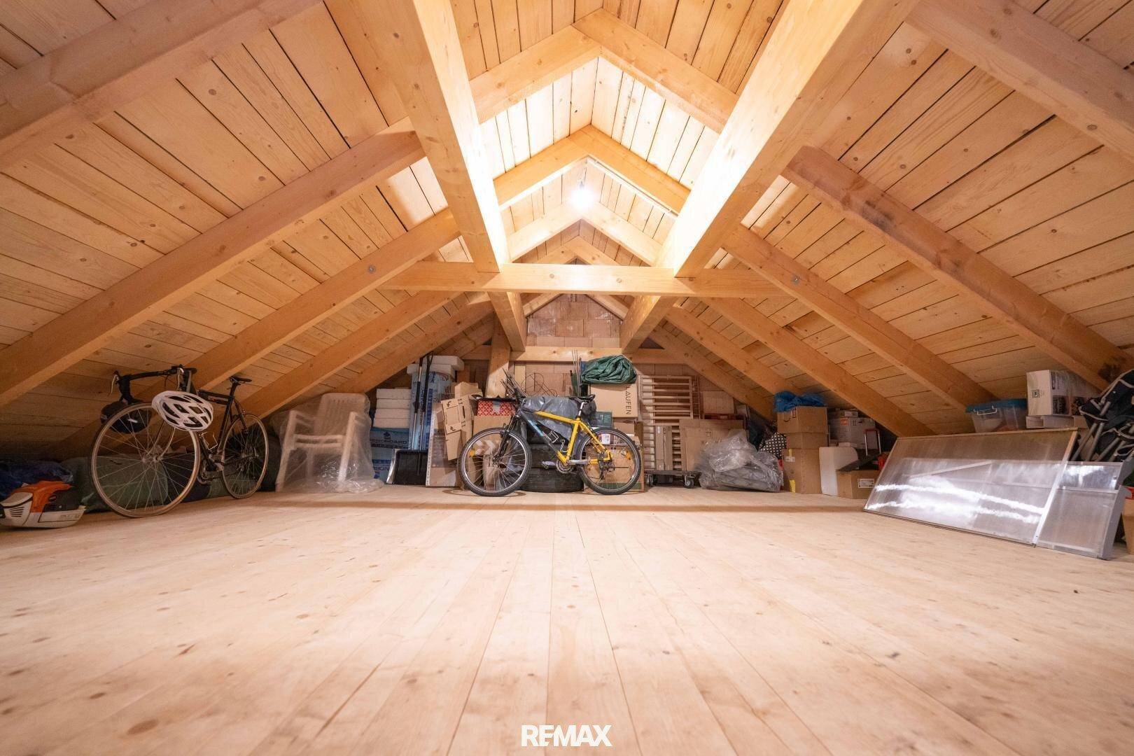 Geräumiger Dachboden mit sichtbaren Holzbalken und -decken, genutzt als Abstellraum.