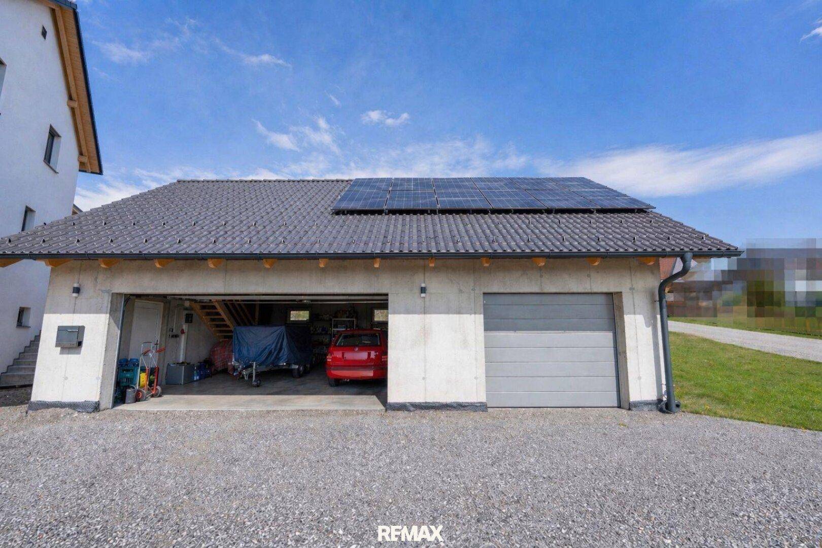 Geräumige Doppelgarage mit zwei Toren und Photovoltaikanlage auf dem Dach.