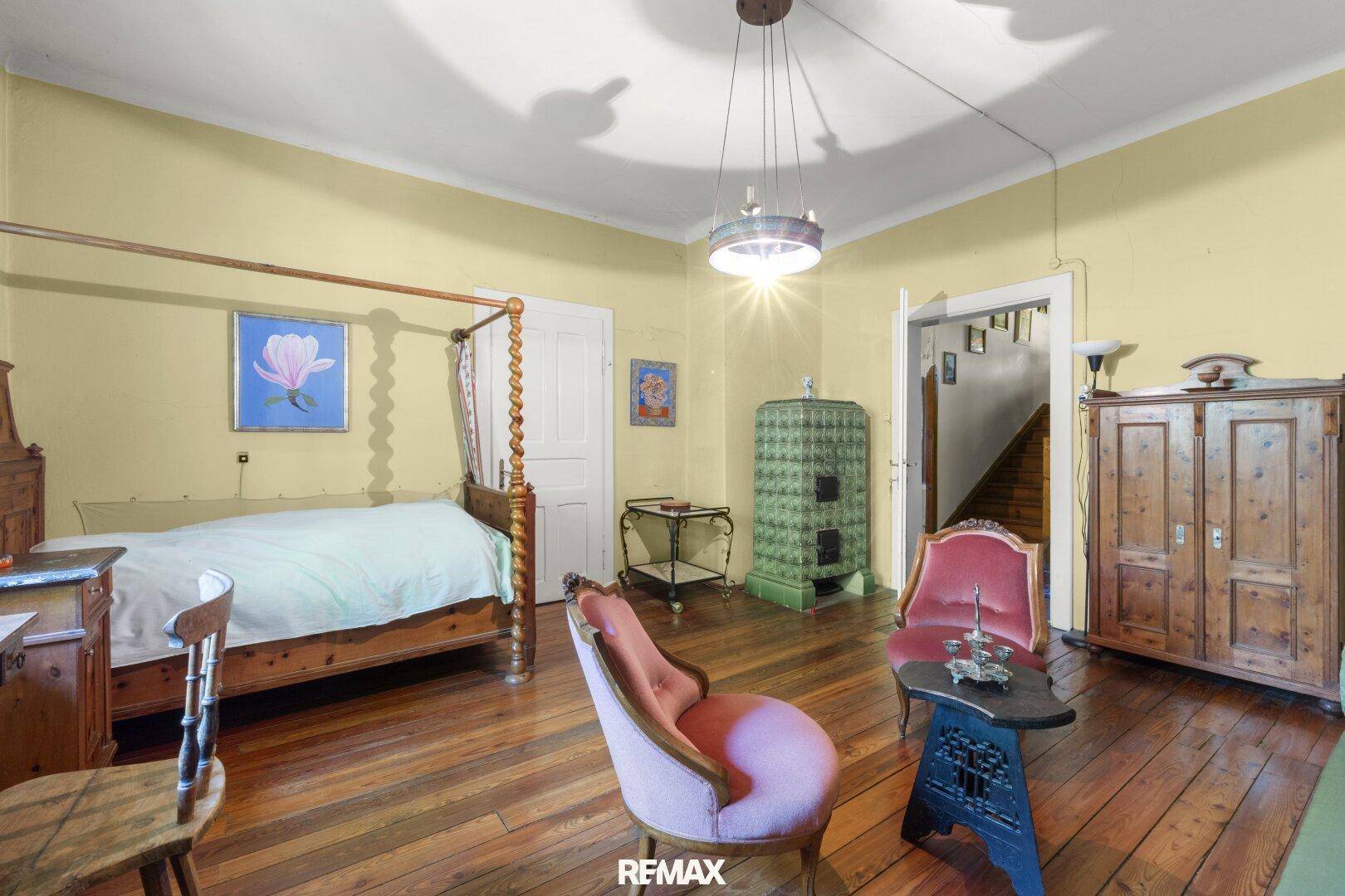 Traditionelles Schlafzimmer mit Holzboden, Himmelbett und antiken Möbeln, gut erhalten.