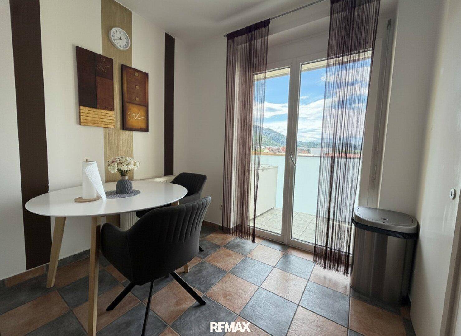 Kleiner Essbereich mit Fliesenboden und Zugang zu einem weiteren Balkon.