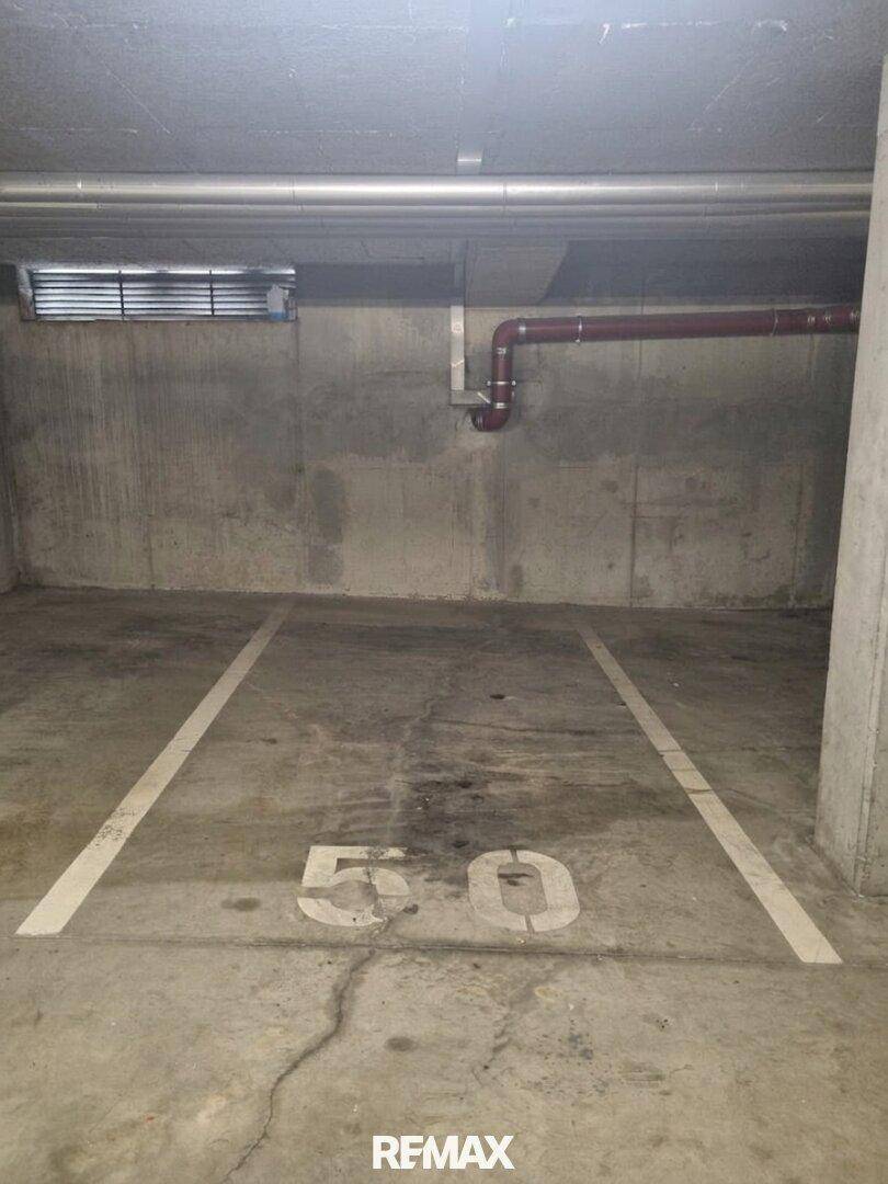 Tiefgaragenstellplatz mit Betonwänden und -boden, gekennzeichnet mit der Nummer 50.