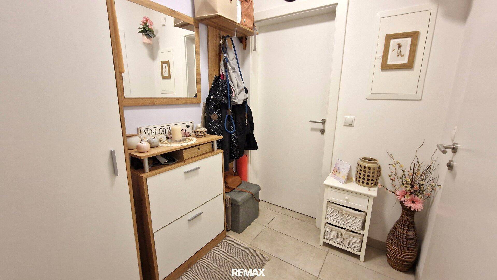 Eingangsbereich mit Garderobe, Spiegel und dekorativen Elementen.