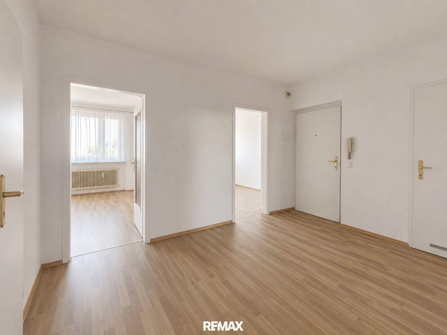 Heller Flur mit Laminatboden und mehreren Türen zu angrenzenden Räumen.