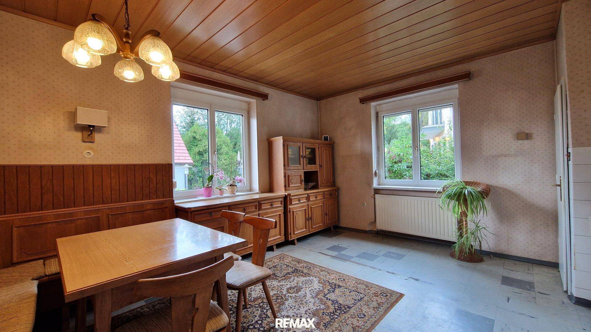 Gemütlicher Essbereich mit Holztäfelung, Holzdecke und traditionellen Möbeln in warmen Tönen.