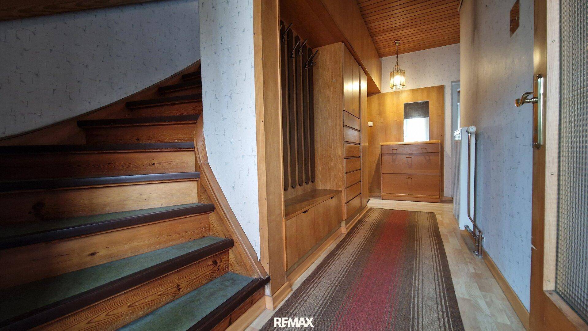 Flur mit Holztreppe, Holzdecke und Einbauschränken im traditionellen Stil, sehr einladend.