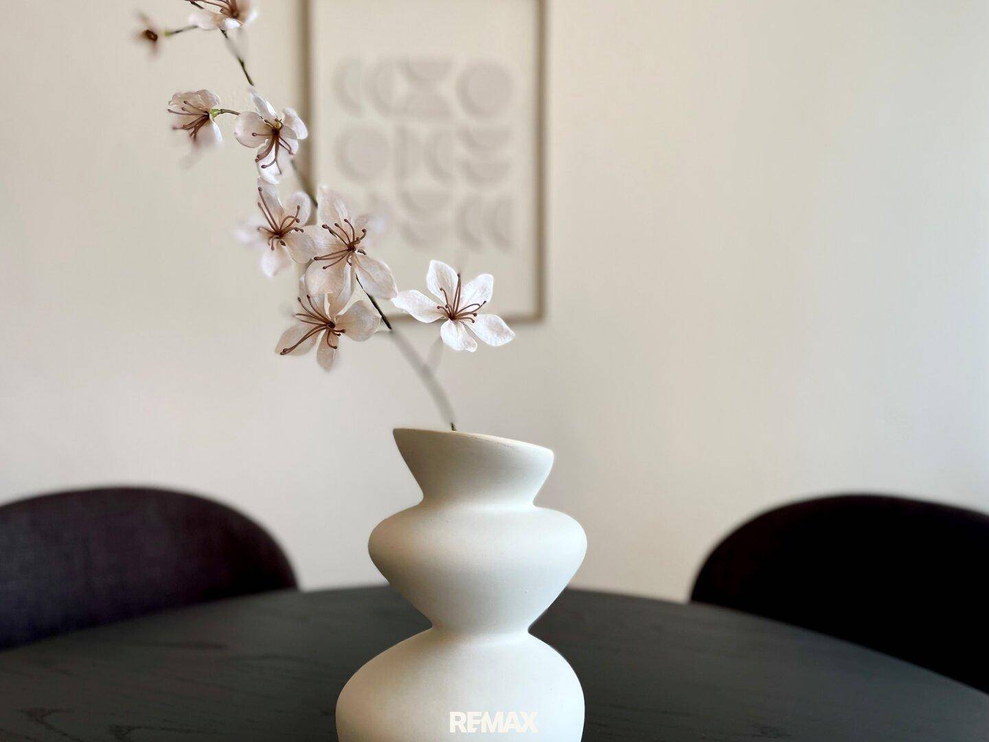 Nahaufnahme einer Vase mit Blumen auf dem Esstisch im modernen Essbereich.