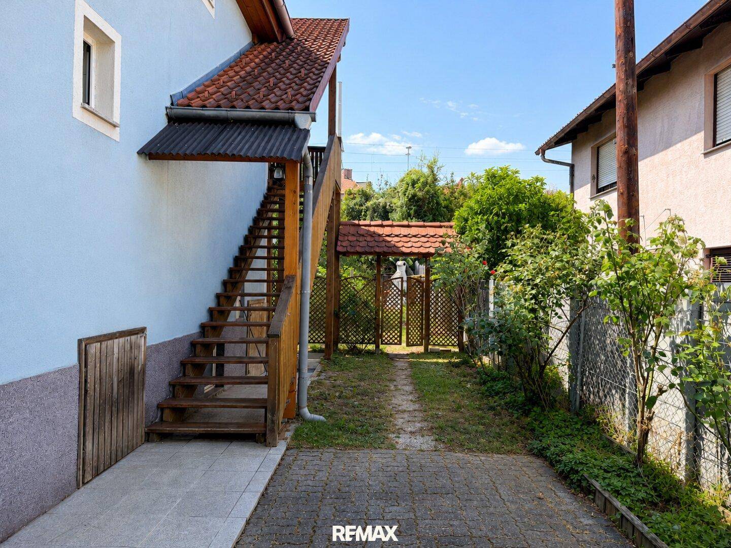 Außenansicht des Gebäudes mit Holztreppe, die zum oberen Stockwerk führt.