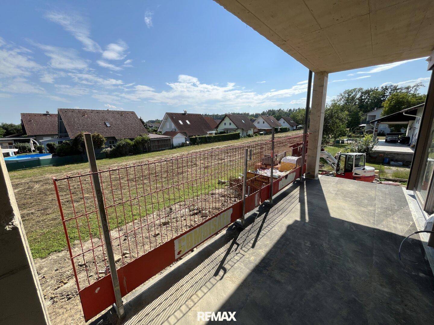 Blick von einem im Bau befindlichen Balkon auf die Umgebung und Nachbarhäuser.