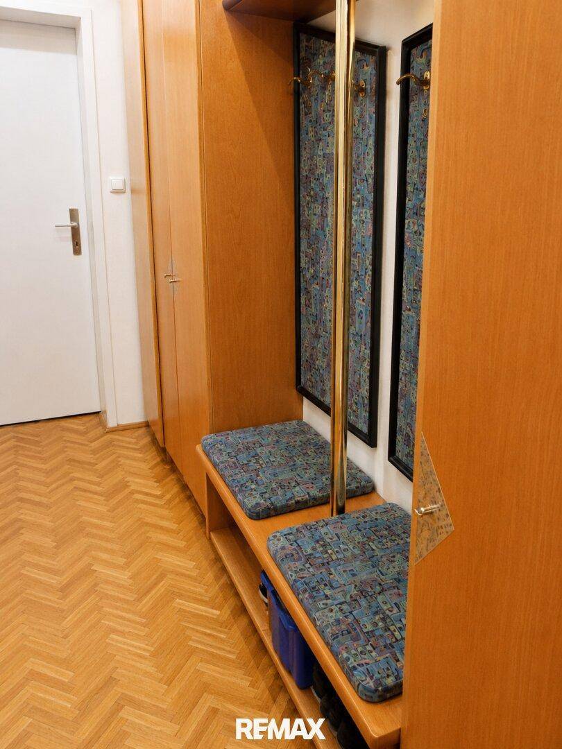 Detailansicht des Flurs mit eingebauter Garderobe, Sitzbank und Spiegeln.
