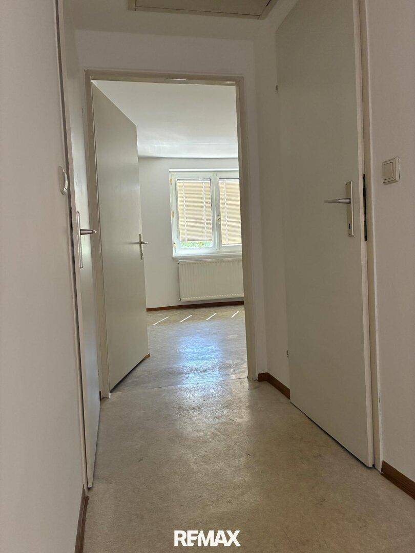 Heller Flur mit Vinylboden und offenen Türen, die den Blick in angrenzende Räume freigeben.