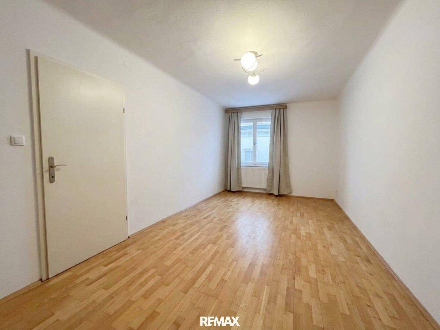 Heller, unmöblierter Raum mit weißen Wänden und Parkettboden, ideal für individuelle Nutzung.