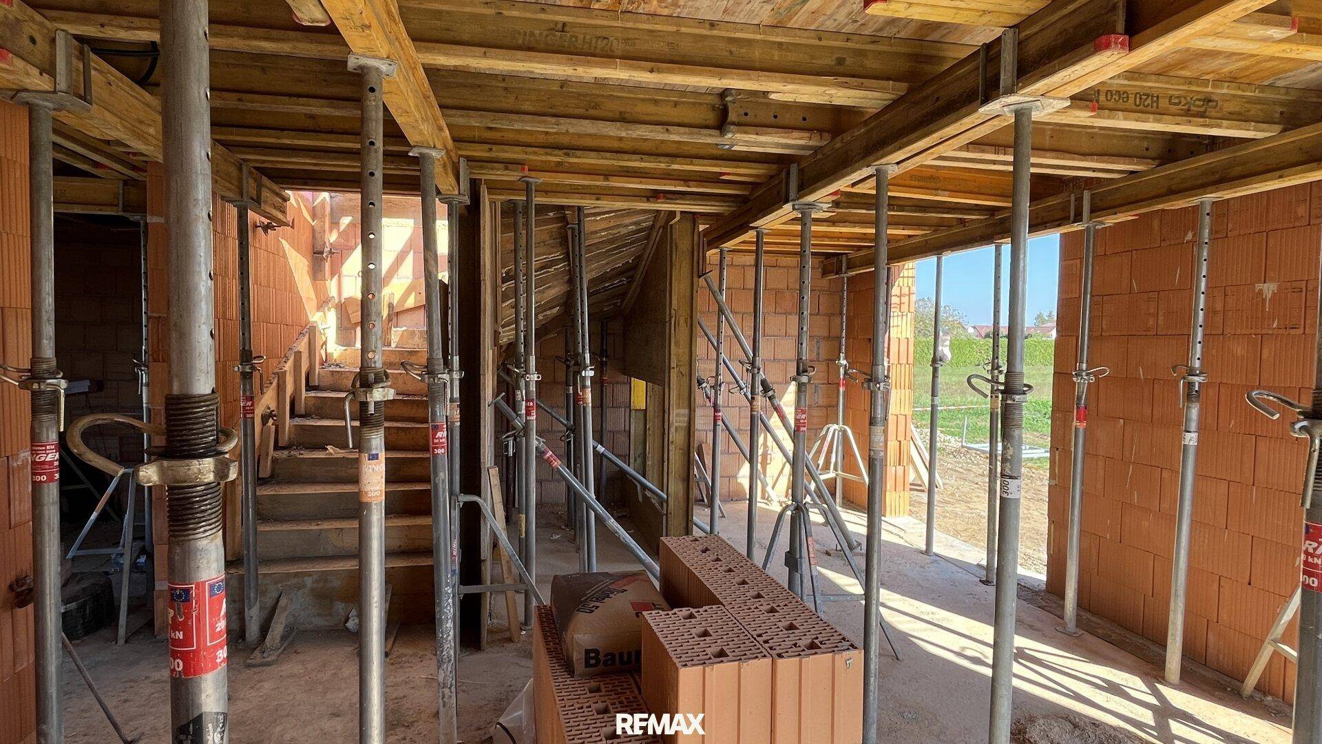 Rohbau mit sichtbaren Treppen und Holzschalungen, bereit für weitere Bauarbeiten.