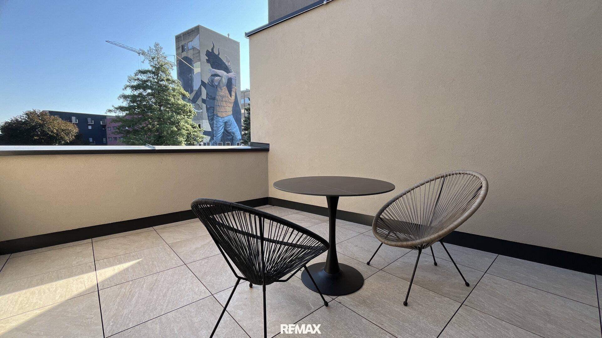 Geräumige Terrasse mit modernen Outdoor-Möbeln und Blick auf die Umgebung.