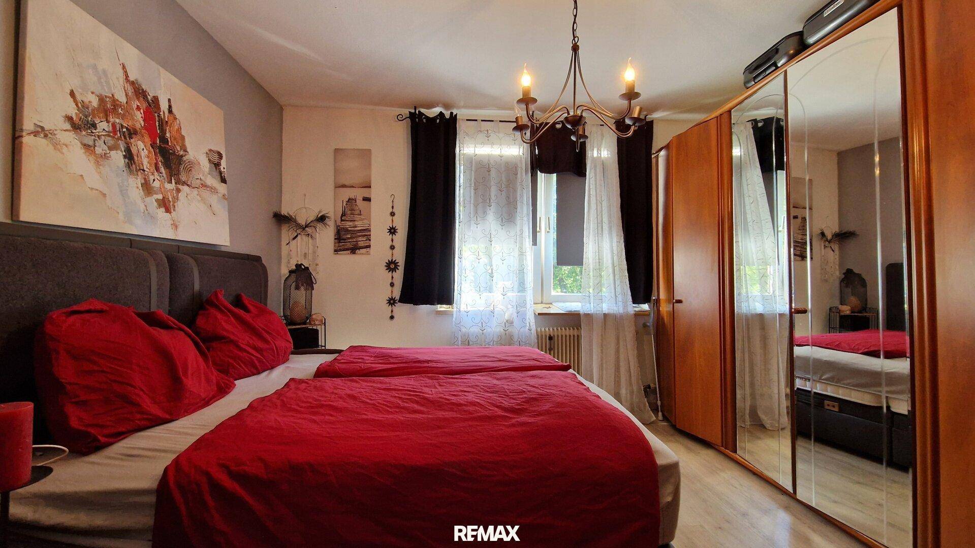 Geräumiges Schlafzimmer mit Doppelbett, Spiegelschrank und Fenster.