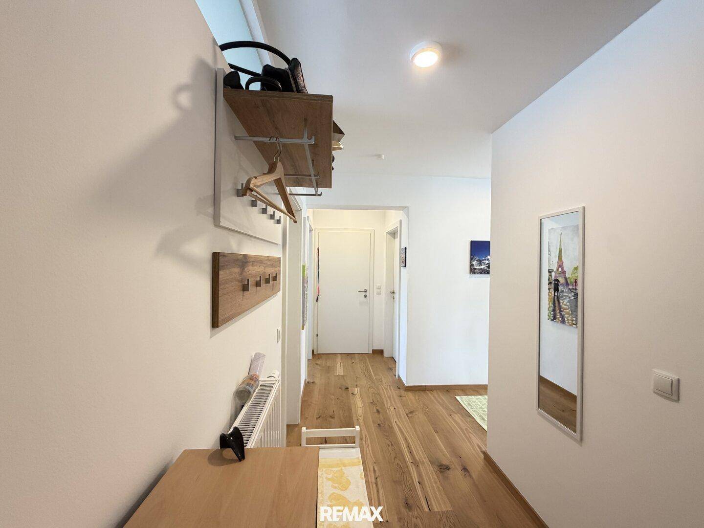 Flur mit Garderobe, Holzboden und Zugang zu weiteren Räumen der Wohnung.