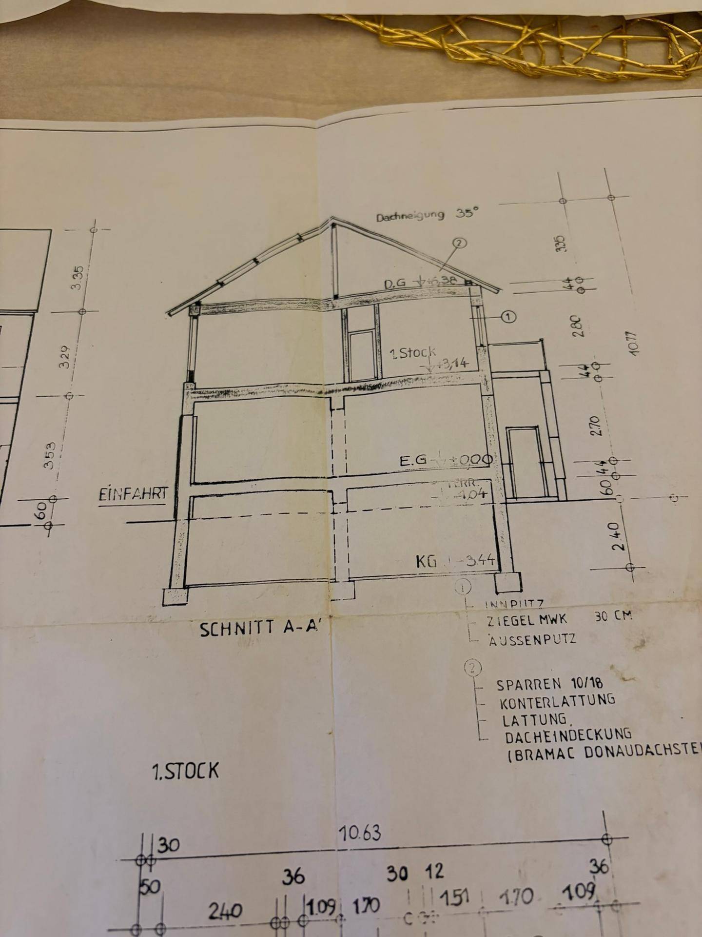 Schnittzeichnung eines Hauses mit verschiedenen Stockwerken und Dachkonstruktion.