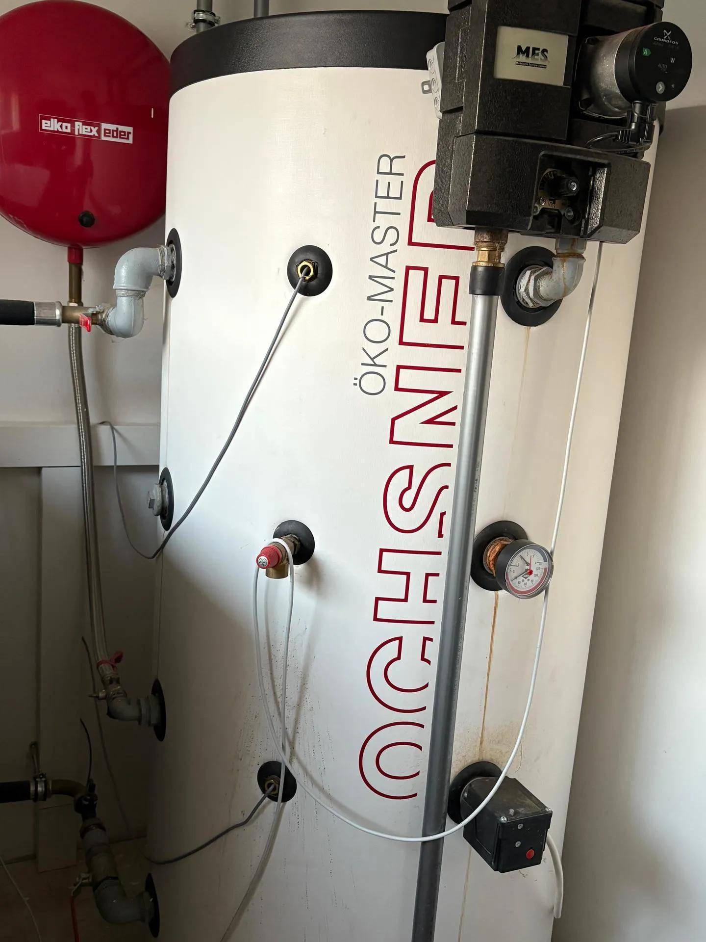 Technikraum mit großem Warmwasserspeicher und zugehörigen Installationen für die Haustechnik.