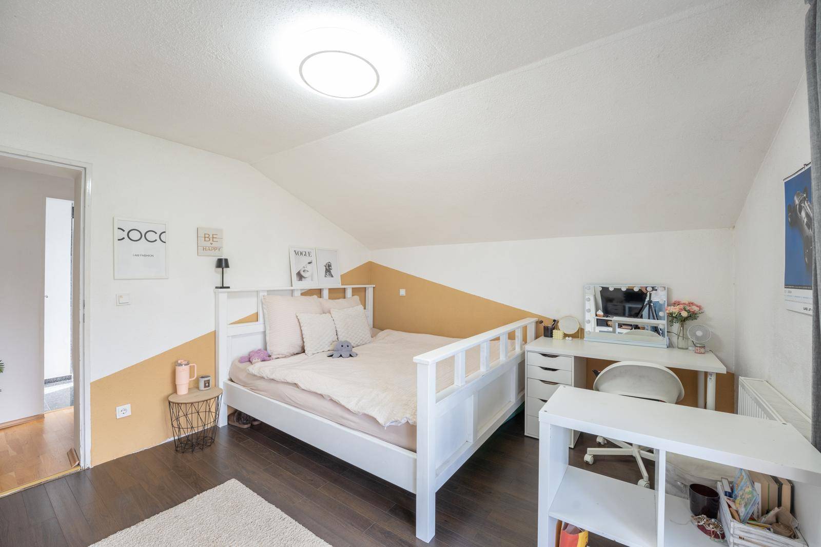 Helles Schlafzimmer mit Holzboden, modernem Bett und Schreibtischbereich, perfekt für Arbeit oder Studium.