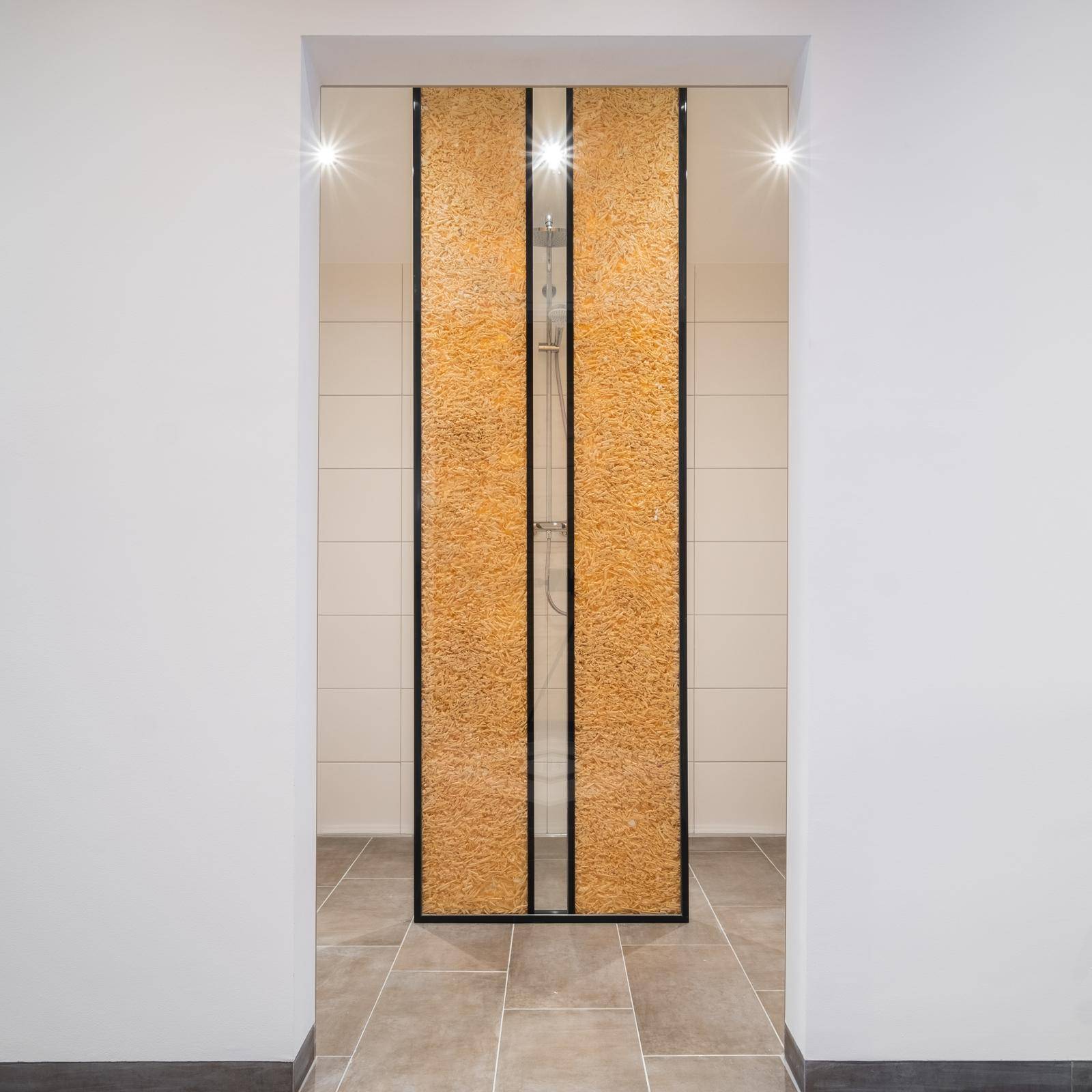 Moderne Duschkabine mit strukturierten Glastüren und hellen Fliesen.