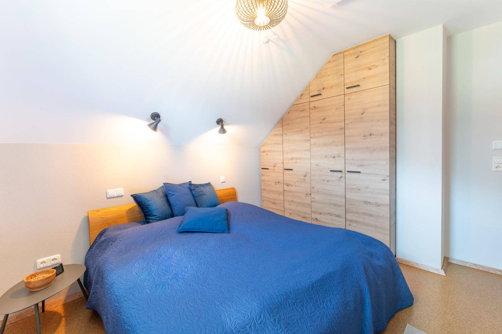 Schlafzimmer im Dachgeschoss mit gemütlichem Doppelbett und maßgefertigtem Einbauschrank.