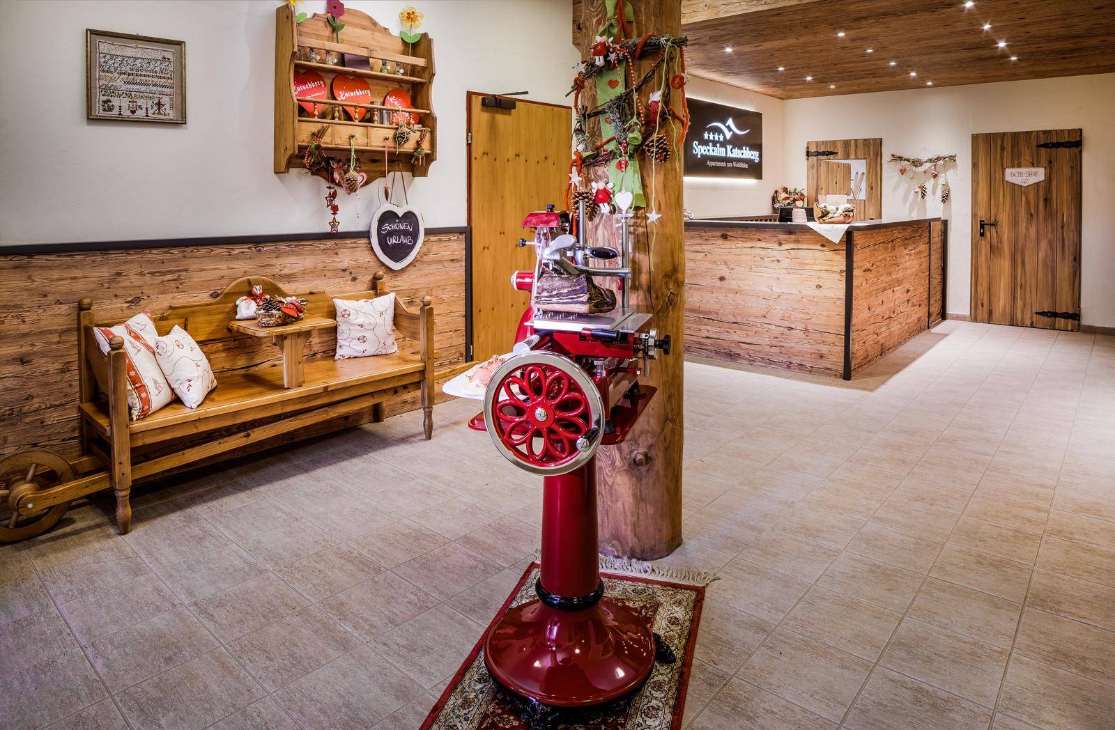 Geräumiger Empfangsbereich mit Holzbänken, Fliesenboden und traditioneller Dekoration.