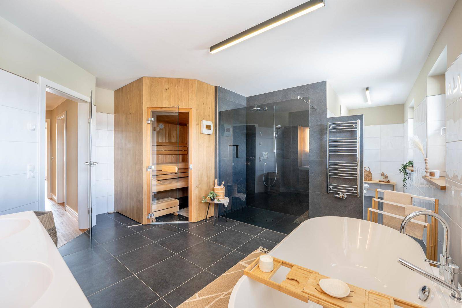 Luxuriöses Badezimmer mit Sauna, freistehender Badewanne und großer begehbarer Dusche.