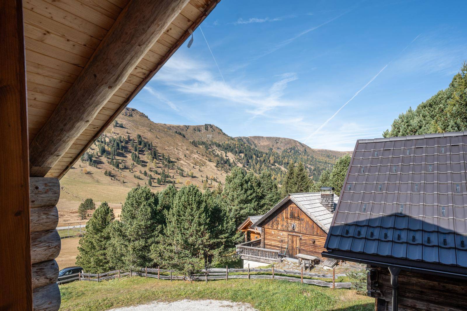 Malerischer Ausblick auf die umliegende Berglandschaft und weitere Holzhäuser.
