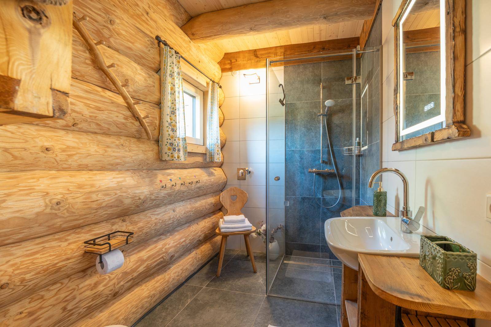 Modernes Badezimmer mit Holzwänden, ebenerdiger Dusche und rustikalem Waschtisch.