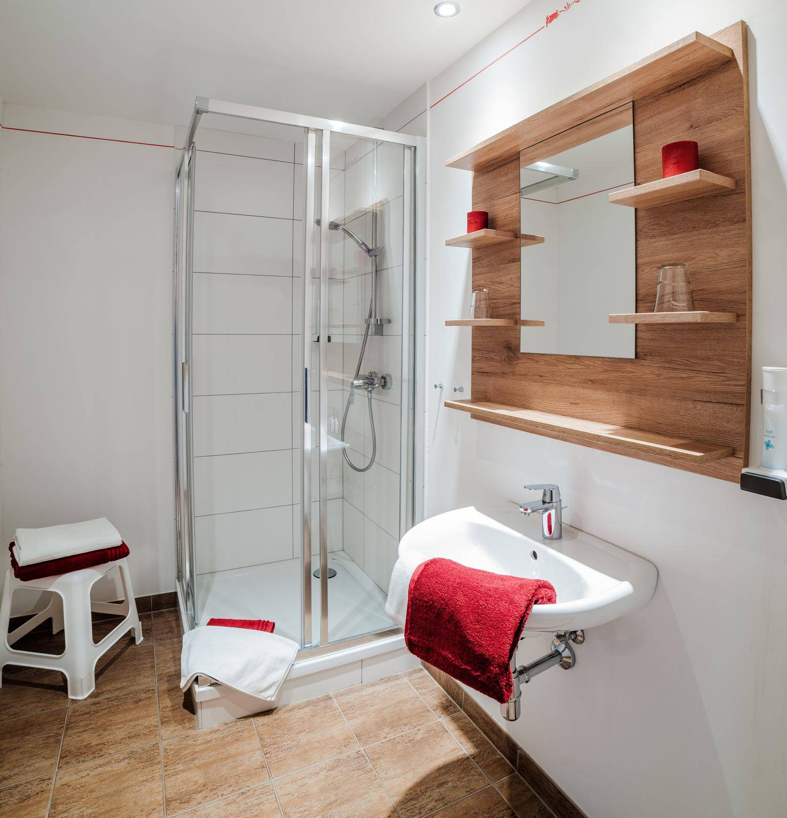 Modernes Badezimmer mit Duschkabine, Einzelwaschbecken und hellen Fliesen.