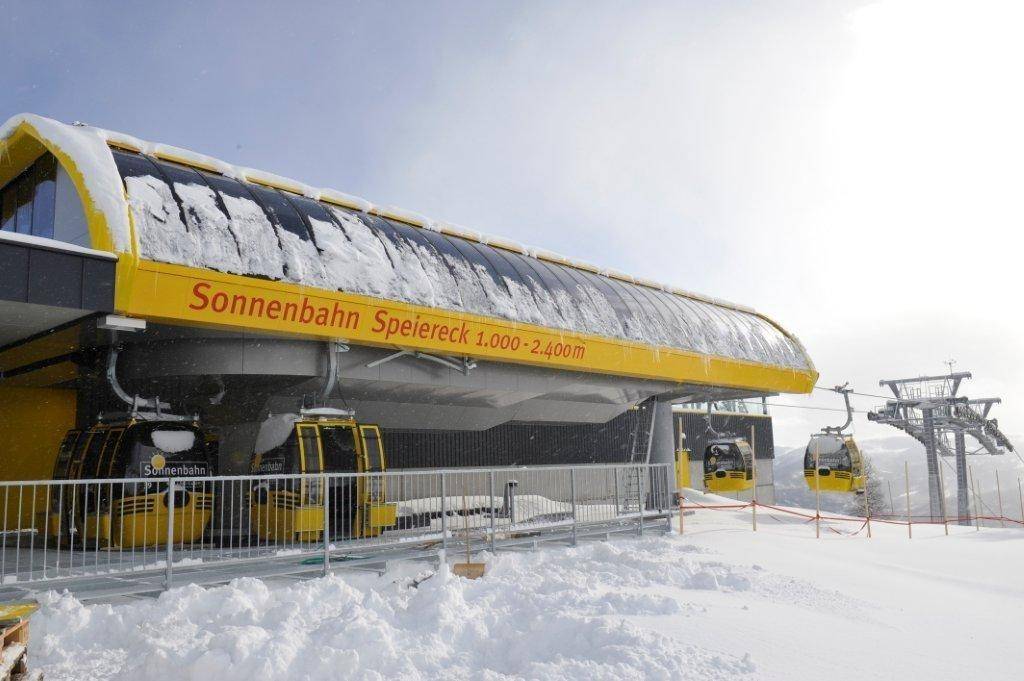 Eine moderne Skiliftstation mit gelben Gondeln, bedeckt mit Schnee in den Bergen.