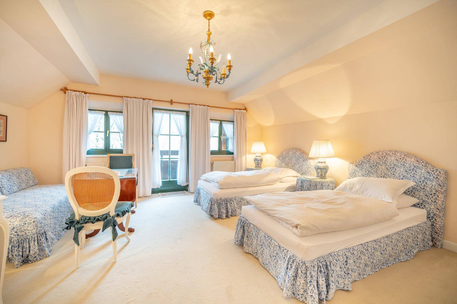 Helles Schlafzimmer mit zwei Einzelbetten, Teppichboden und Zugang zum Balkon.