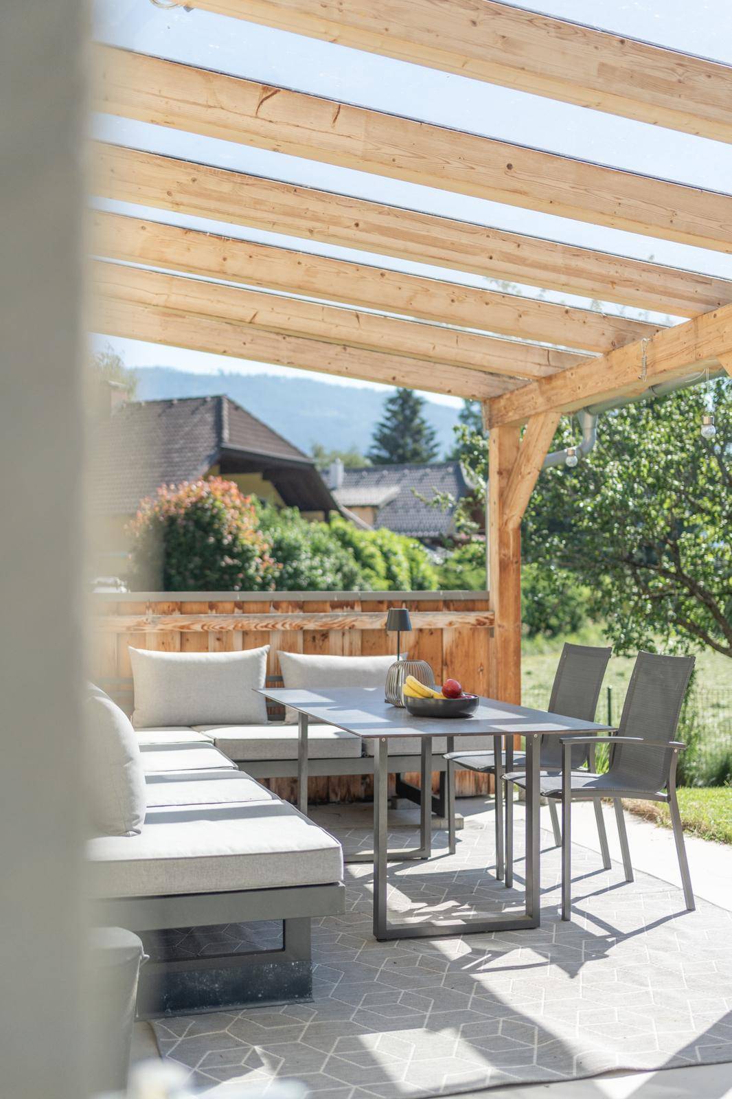 Überdachte Terrasse mit modernen Gartenmöbeln, ideal für entspannte Stunden im Freien.