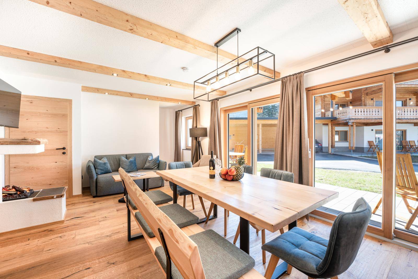 Heller Wohn- und Essbereich mit Holzboden, großen Schiebetüren und Zugang zur Terrasse.