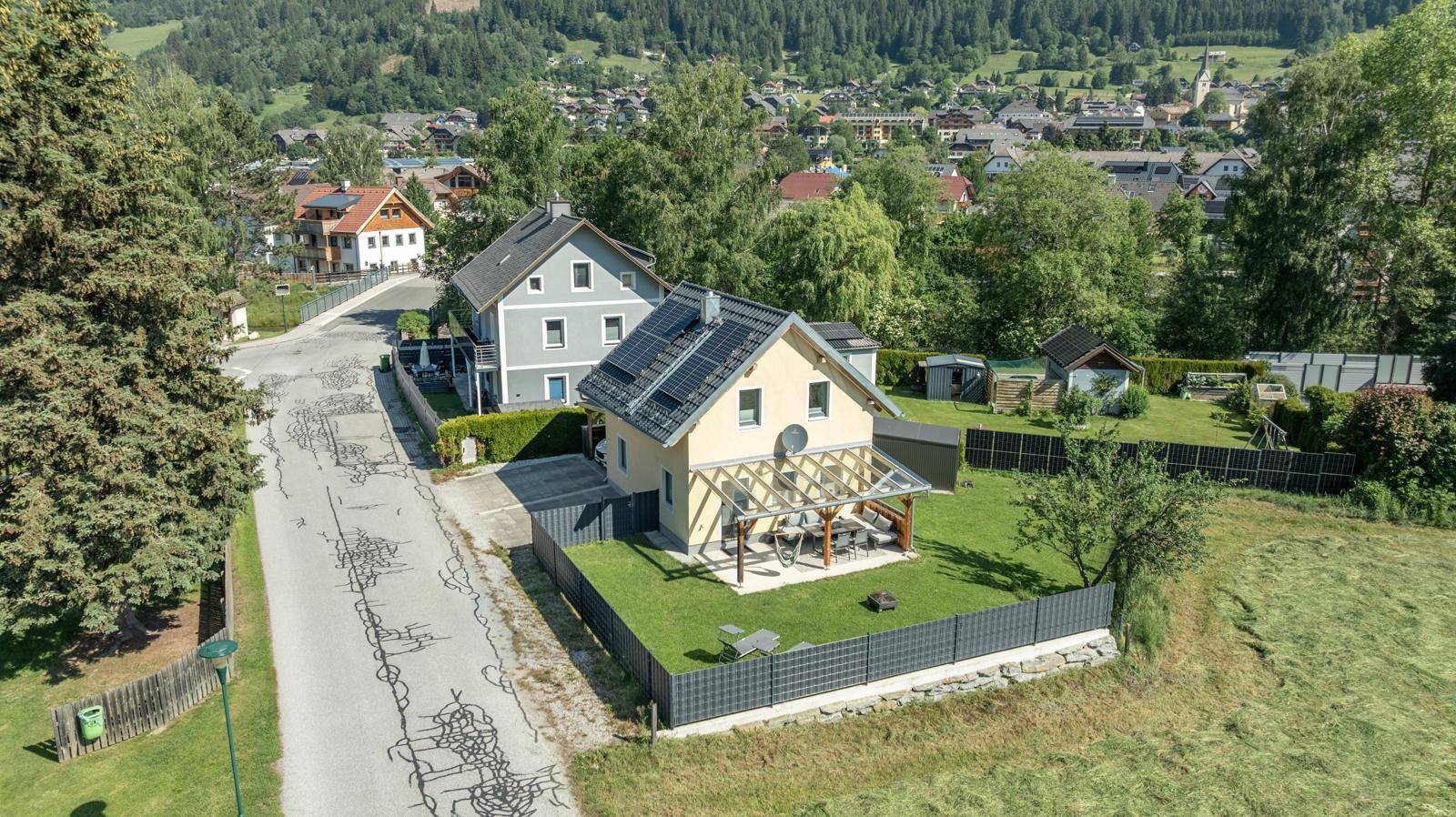 Luftaufnahme des Hauses mit Garten, Terrasse und Photovoltaikanlage in ländlicher Umgebung.