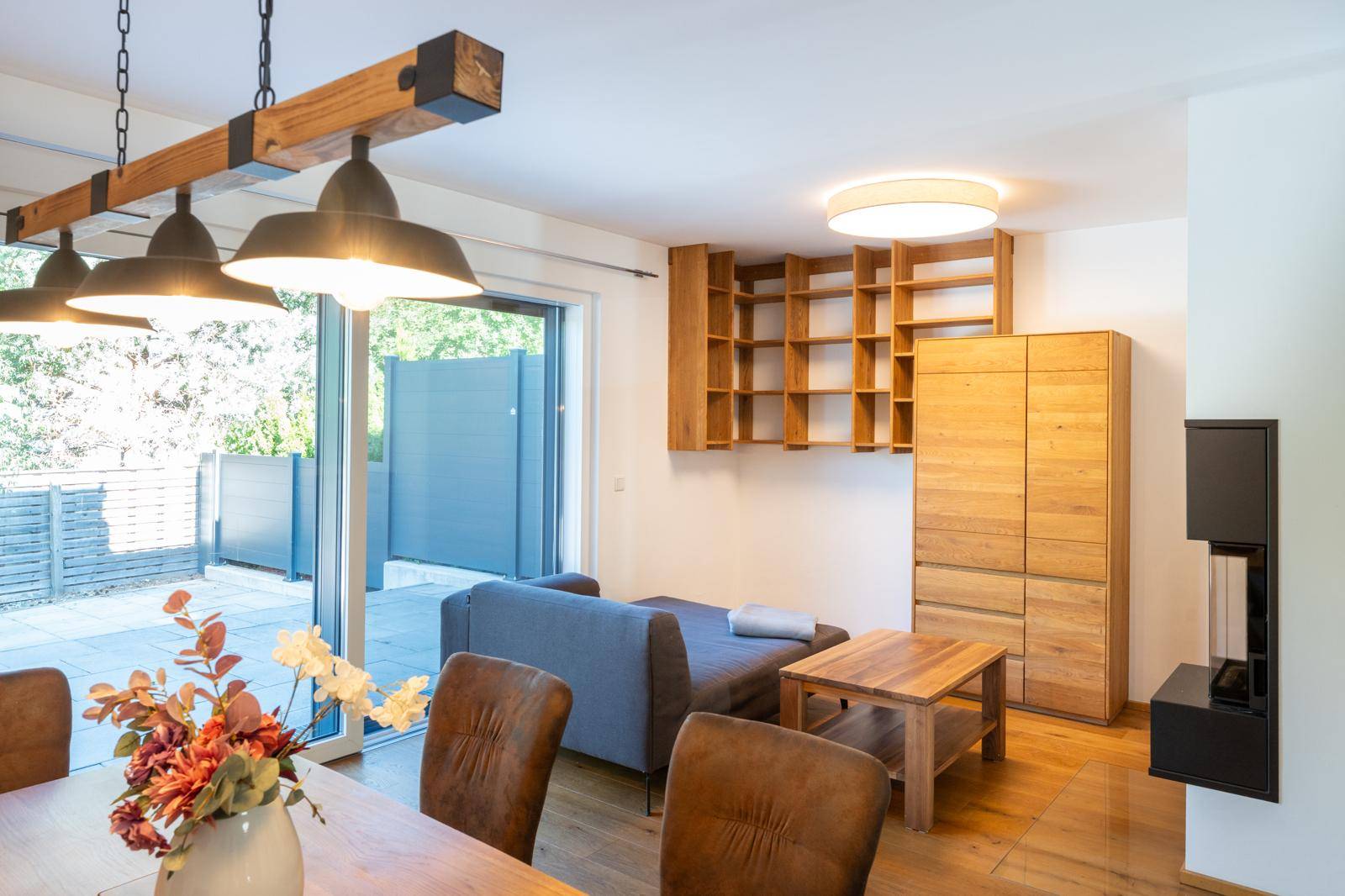 Gemütliches Wohnzimmer mit Holzboden, Sofa und direktem Zugang zur Terrasse.