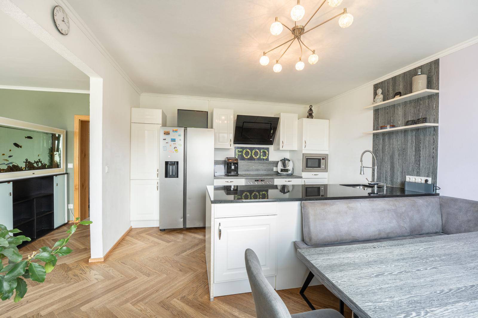Offene Küche mit Essbereich und Blick in das angrenzende Wohnzimmer, ausgestattet mit modernen Möbeln.