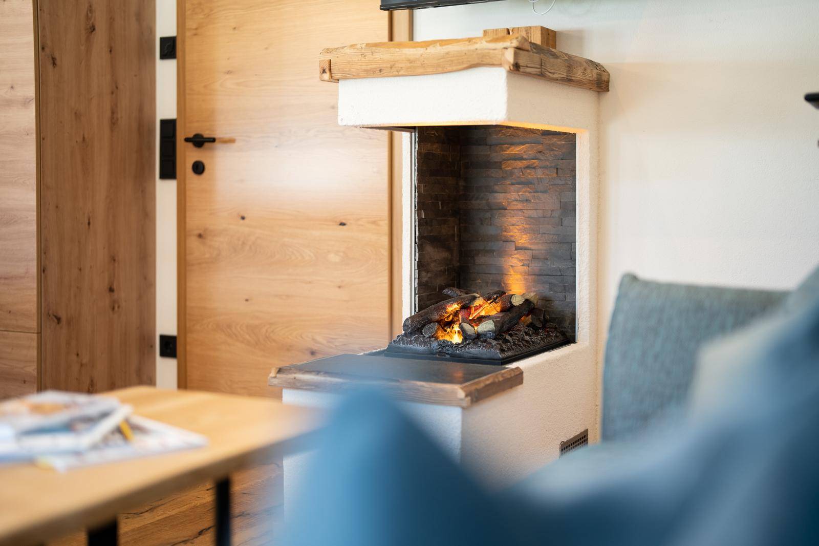 Detailaufnahme des modernen Kamins mit Holzverkleidung und gemütlicher Atmosphäre im Wohnzimmer.