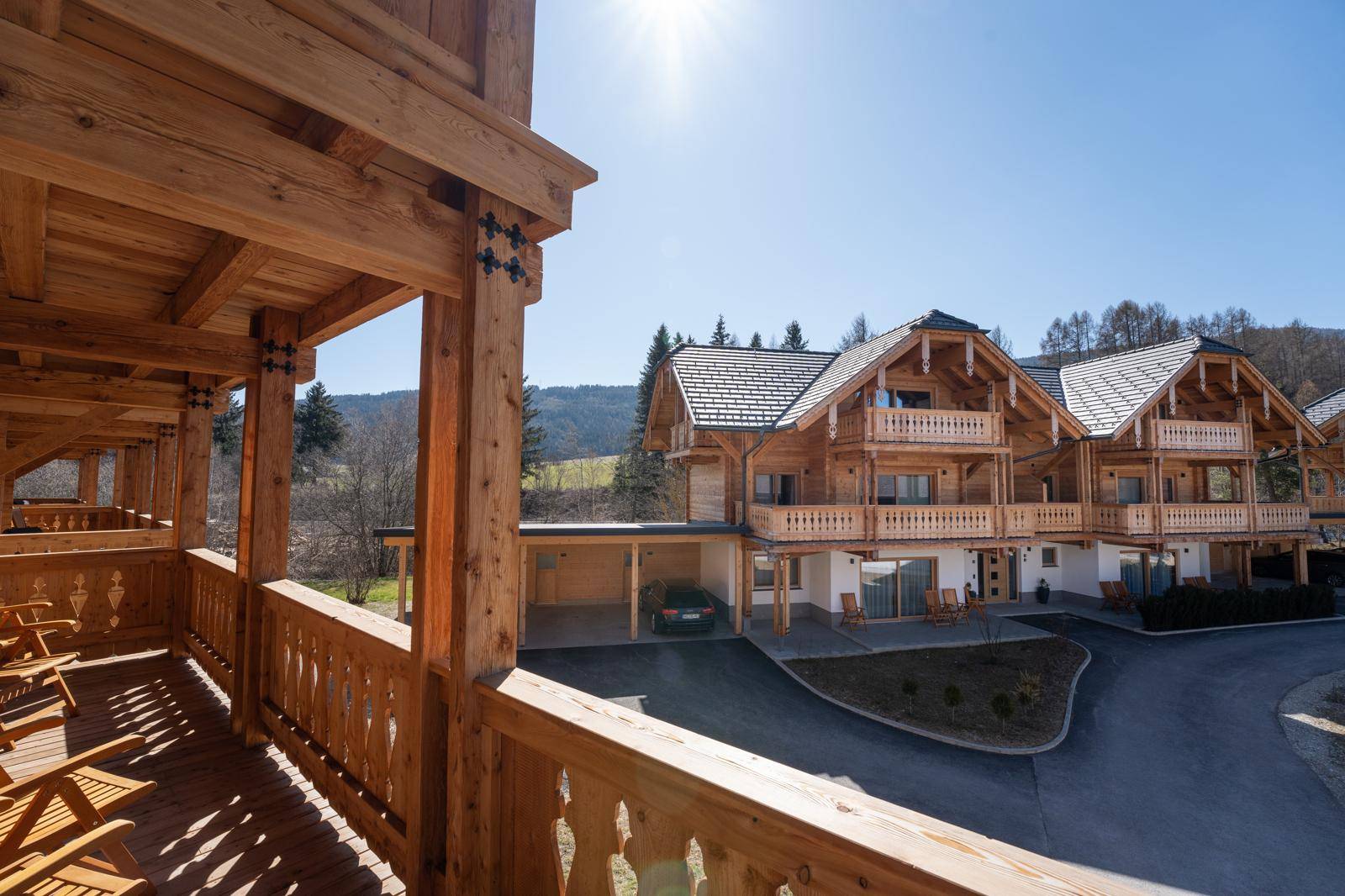 Großer Holzbalkon mit Blick auf die umliegenden Häuser und die Berglandschaft.