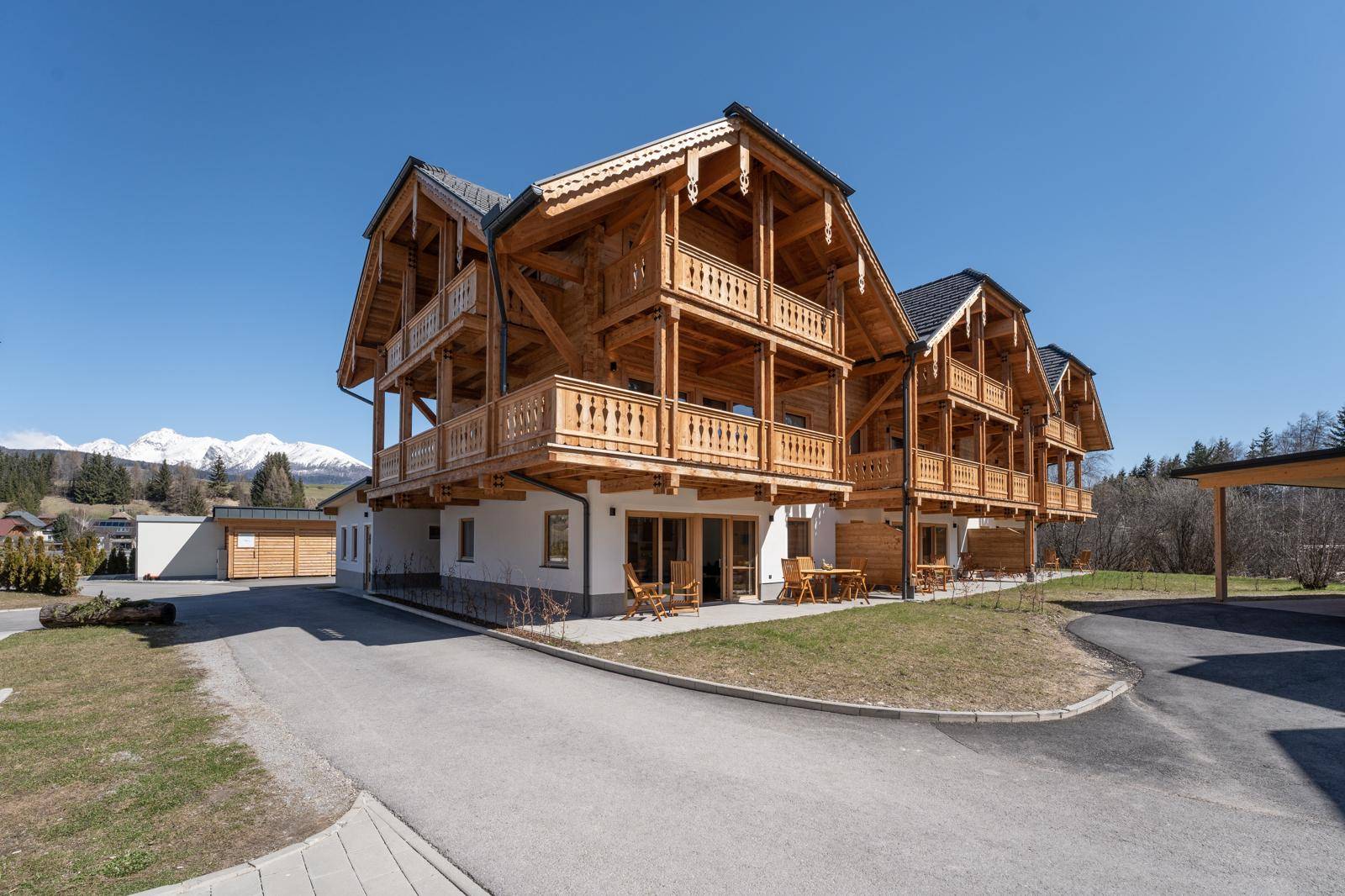 Attraktives Holzhaus im alpinen Stil mit mehreren Balkonen und Bergblick.