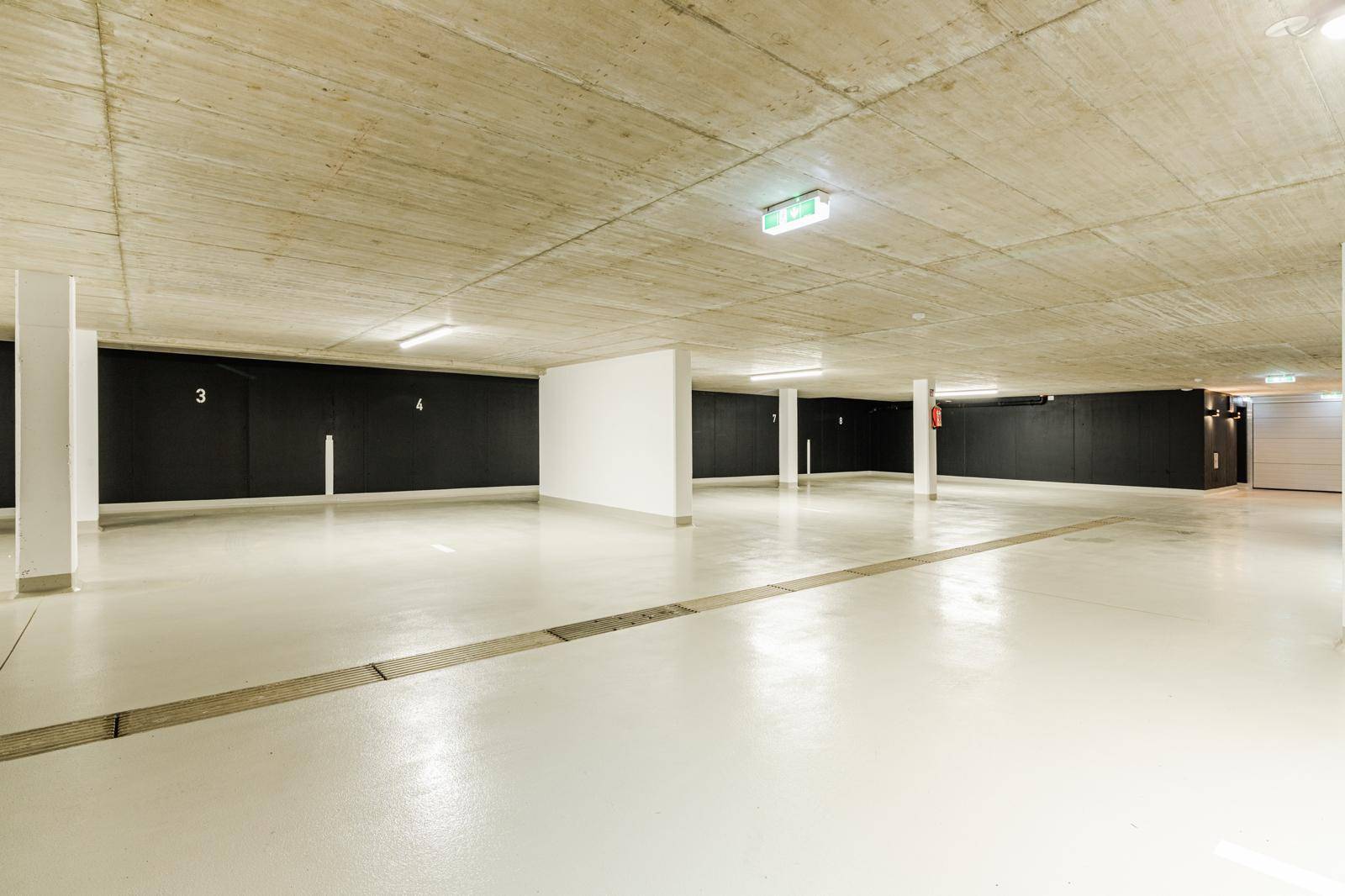 Geräumige Tiefgarage mit hellen Böden und ausreichend Stellplätzen.