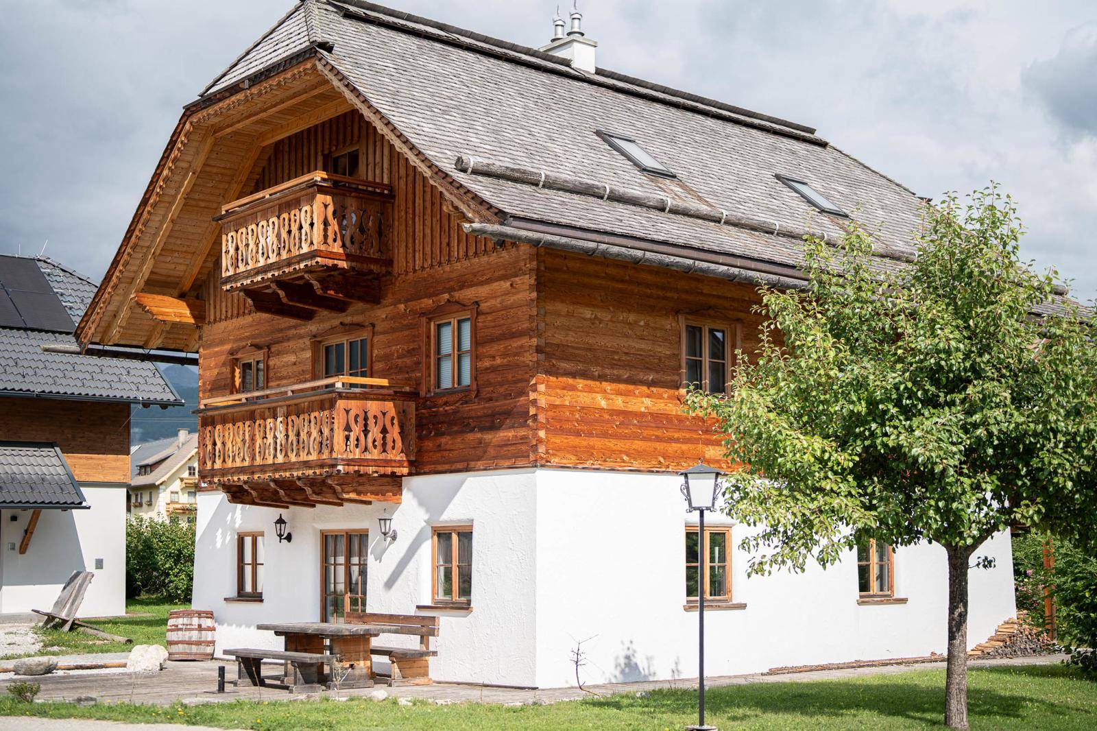 Charmantes Holzchalet mit traditioneller Architektur, Balkonen und gepflegtem Vorgarten.