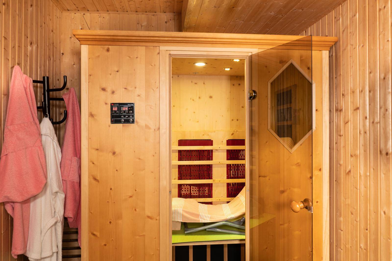 Gemütliche Sauna mit Holzverkleidung und Infrarotstrahlern für Entspannung.