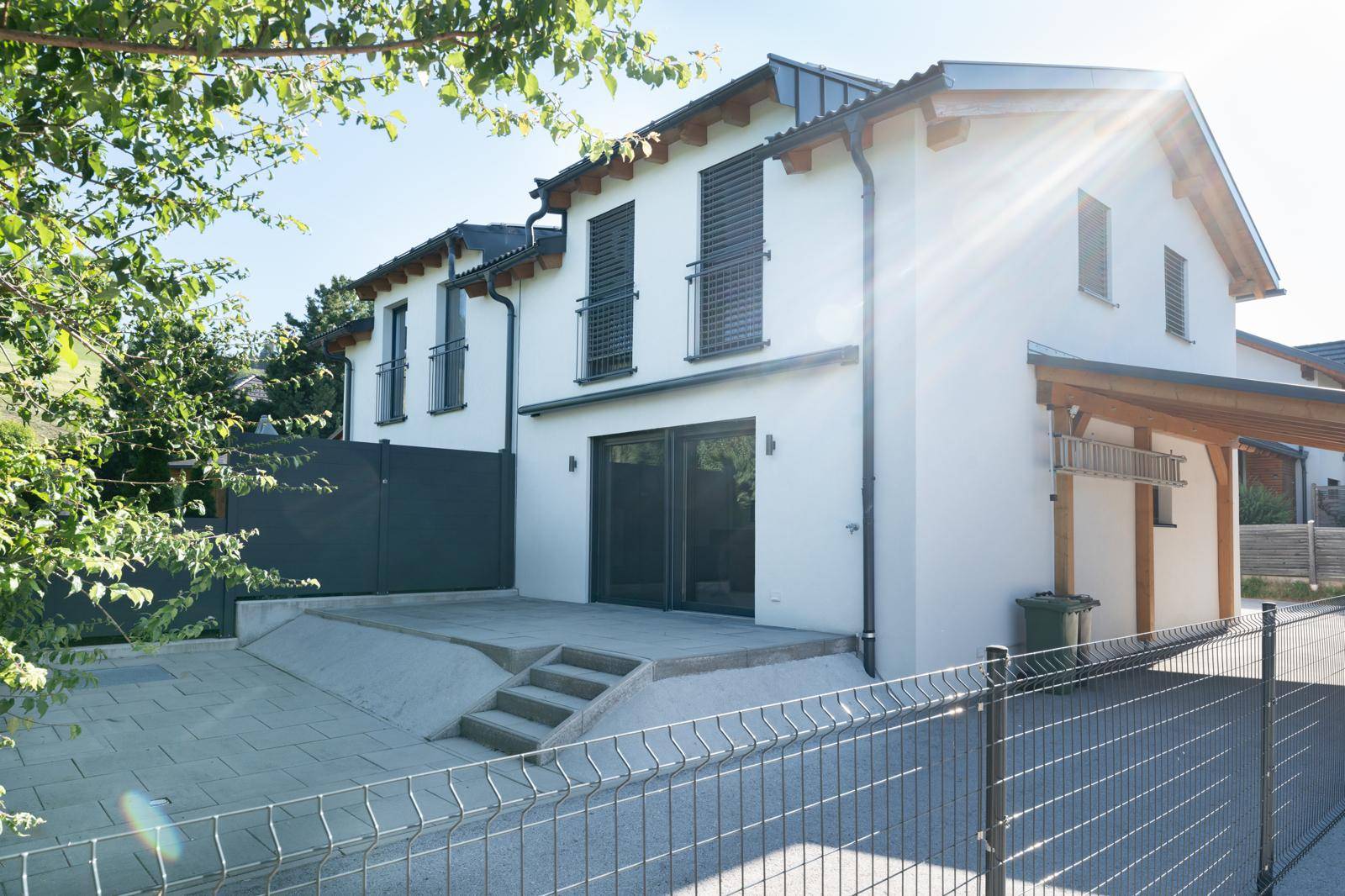 Rückseite des Hauses mit sonniger Terrasse und Zugang zum Gartenbereich.