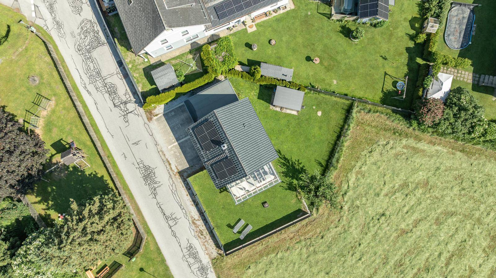 Vogelperspektive des Grundstücks mit Haus, Garten, Carport und Photovoltaikanlage.
