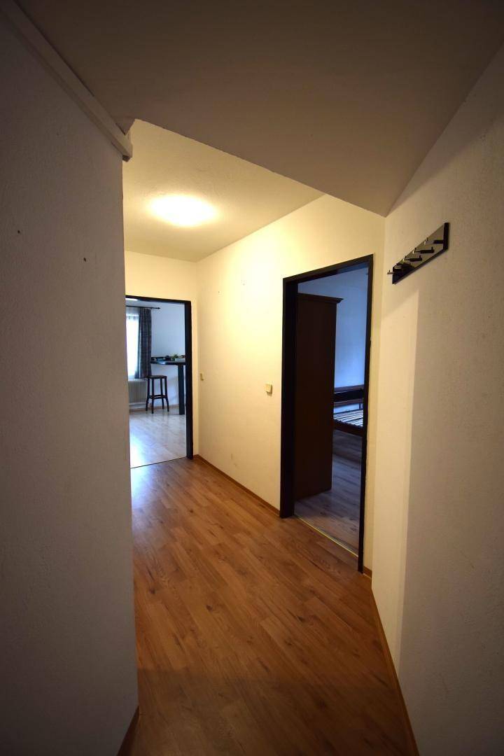Heller Flur mit Laminatboden, der zu verschiedenen Zimmern führt und eine Garderobe bietet.