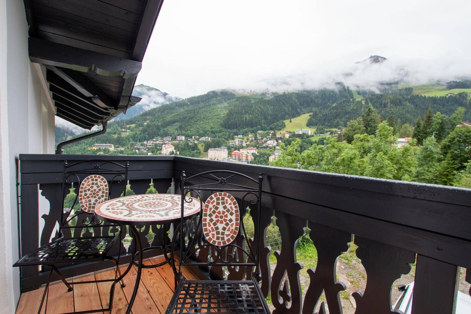 Balkon mit schmiedeeisernen Möbeln und weitem Blick auf die Berglandschaft.