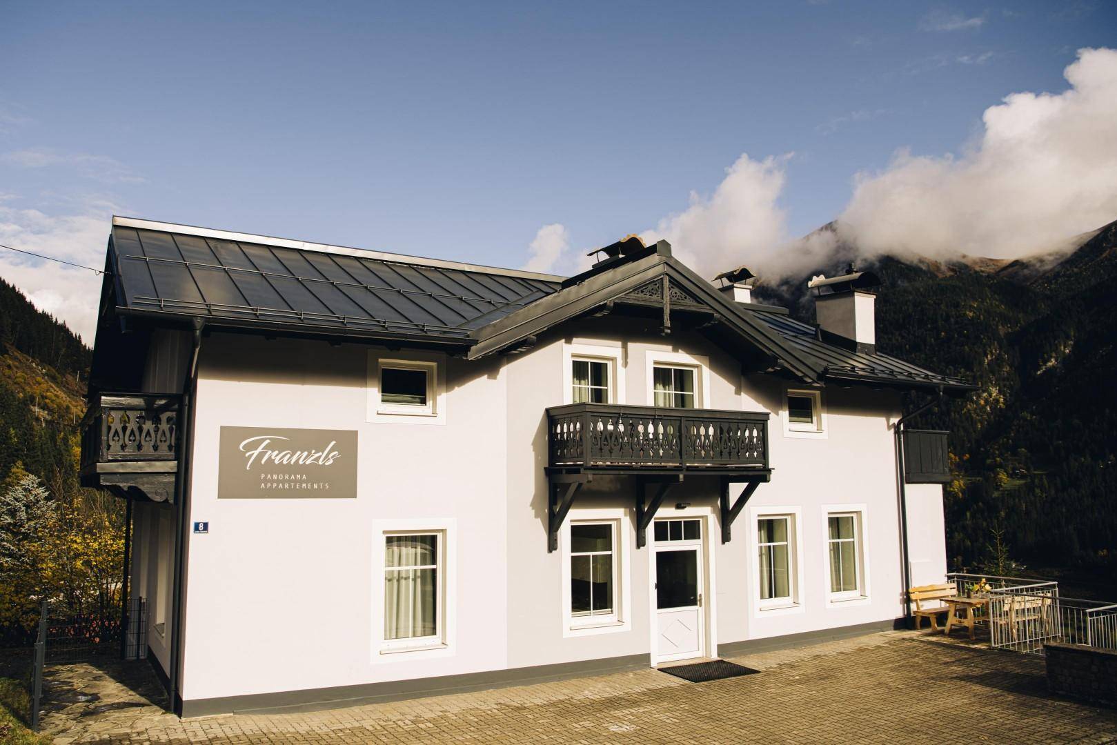 Charmantes Haus mit traditionellem Balkon und Bergblick in alpiner Umgebung.